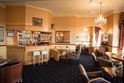 a restaurant with a bar and tables and chairs at Furzedown Hotel in Great Yarmouth