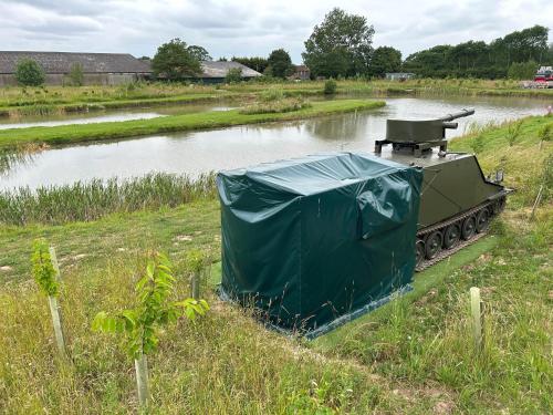 a tank in a field next to a body of water at The Tank in Friskney
