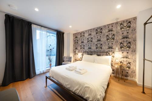 a bedroom with a bed with two towels on it at Crashpads Shoreditch Apartments - The Club Row Collection in London