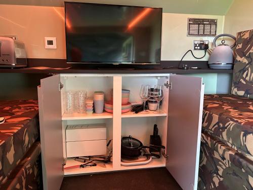 a room with two beds and a cabinet with a tv at The Tank in Friskney