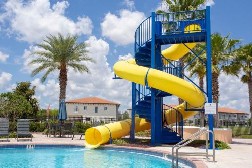 a blue and yellow slide next to a swimming pool at 6BR Resort Private Pool BBQ in Davenport