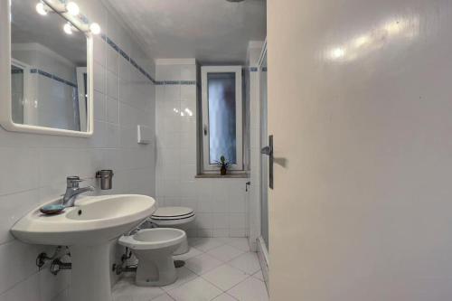 Baño blanco con lavabo y aseo en Villa Federigo - Monte Argentario, en Monte Argentario