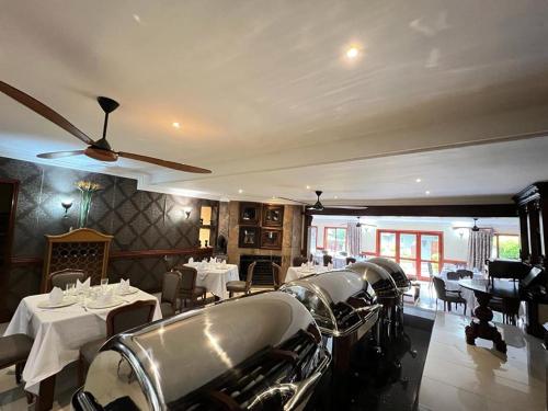 a dining room with tables and chairs in a restaurant at Limpopo Guest Manor in Polokwane