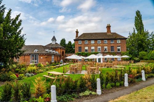 um edifício com mesas e cadeiras em frente em Mytton and Mermaid - Brunning and Price em Shrewsbury