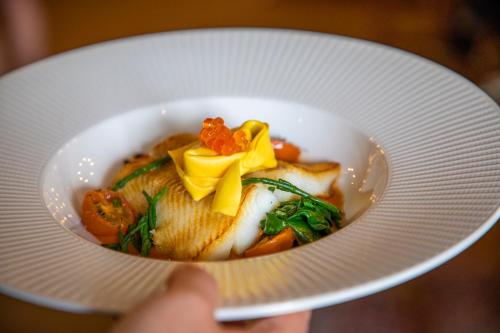 a person holding a white plate with a bowl of food at Mytton and Mermaid - Brunning and Price in Shrewsbury