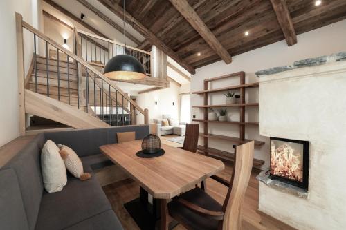 a living room with a table and a fireplace at Alpine Lofts M26 in Grossarl