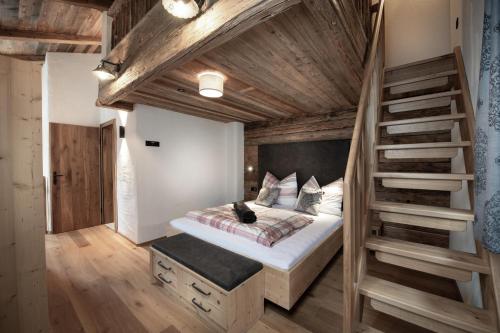 een slaapkamer met een groot bed en een trap bij Alpine Lofts M26 in Grossarl