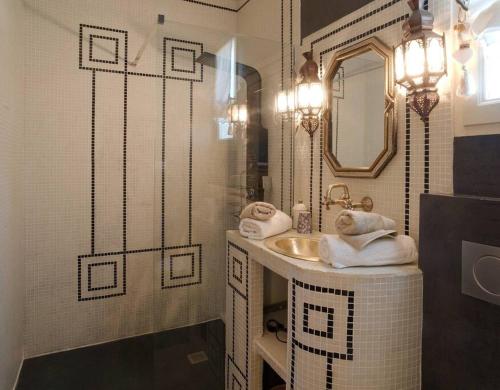 a bathroom with a sink and a mirror and towels at Demeure de charme, piscine, centre St Rémy à pied in Saint-Rémy-de-Provence