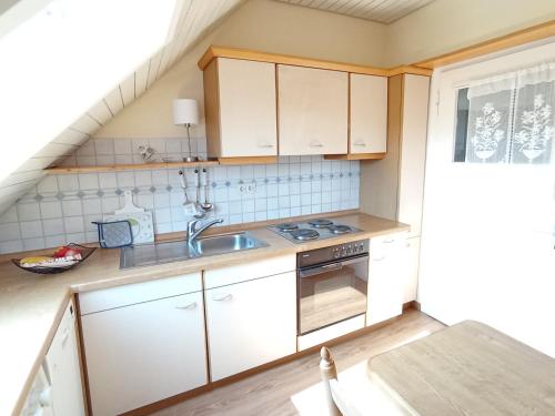 a kitchen with white cabinets and a sink at Dachgeschoss - Maria von Berg - Wohnen auf Zeit in Rottweil