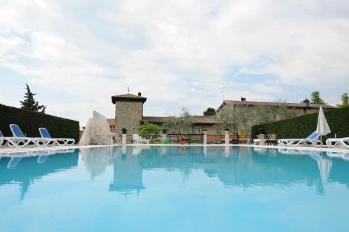 een groot zwembad met blauw water voor een gebouw bij Cà Donzella in Lazise