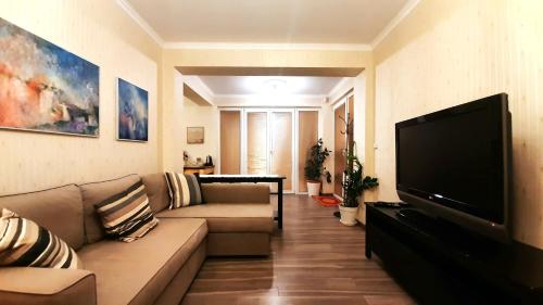 ein Wohnzimmer mit einem Sofa und einem Flachbild-TV in der Unterkunft Studio with Terrace Near Prague Airport 