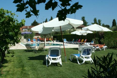 un grupo de sillas y sombrillas junto a una piscina en Cà Donzella, en Lazise