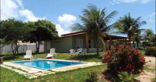 uma casa com piscina no quintal em Pousada da Chris em Maxaranguape