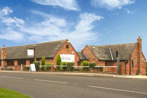 a brick building on the side of a street at The mill wheel in Hartshorne