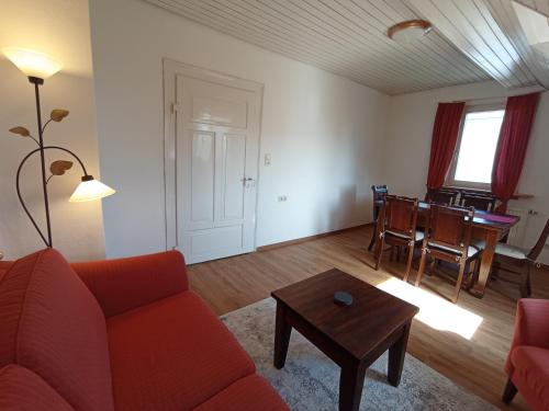 a living room with a red couch and a table at Dachgeschoss - Maria von Berg - Wohnen auf Zeit in Rottweil