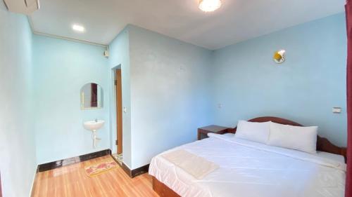 a bedroom with a bed with a blue wall at Koh Rong 71 Guesthouse in Koh Rong Island