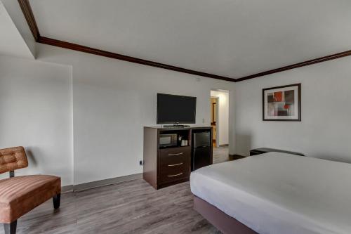 a hotel room with a bed and a flat screen tv at Park Inn by Radisson, Salt Lake City-Midvale in Midvale