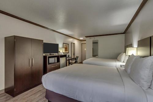 a hotel room with two beds and a kitchen at Park Inn by Radisson, Salt Lake City-Midvale in Midvale