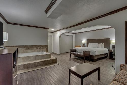 a hotel room with a bed and a bath tub at Park Inn by Radisson, Salt Lake City-Midvale in Midvale