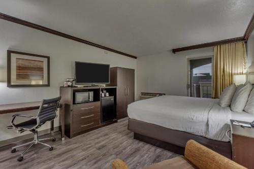 a hotel room with a bed and a desk and a television at Park Inn by Radisson, Salt Lake City-Midvale in Midvale