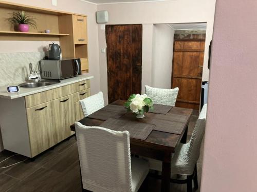 eine Küche mit einem Holztisch und Stühlen sowie eine Küche mit einer Spüle in der Unterkunft Къща за гости Теяна in Trjawna
