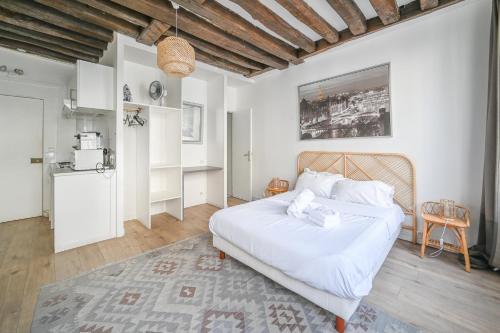 Cet appartement comprend une chambre avec un lit blanc et une cuisine. dans l'établissement Cléry 43, à Paris