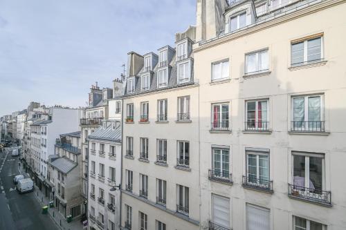 un grand bâtiment blanc avec des fenêtres sur une rue de la ville dans l'établissement Cléry 43, à Paris