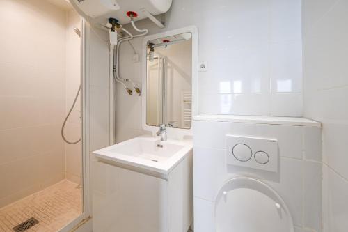 une salle de bain blanche avec un lavabo et des toilettes dans l'établissement Cléry 43, à Paris