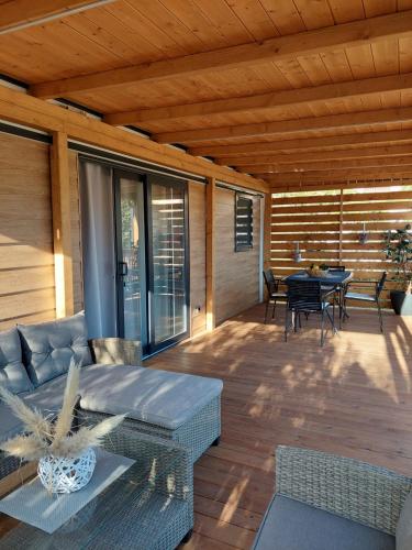 a patio with a couch and a table on a deck at Julija Mobile Lux in Vodice