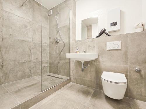 uma casa de banho com um chuveiro, um WC e um lavatório. em RAJ Living - 2 or 3 Room Apartments - 15 Min zur Messe DUS & 10 Min Old Town DUS em Dusseldorf