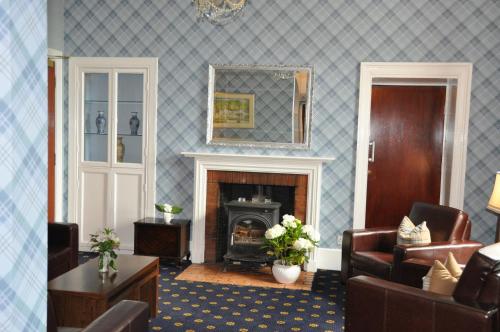 a living room with a fireplace and a mirror at Kingswood Hotel in Burntisland