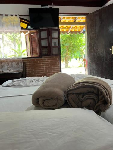 a bedroom with two beds with towels on them at Pesque pague pousada do Carlinho in Pinheiral