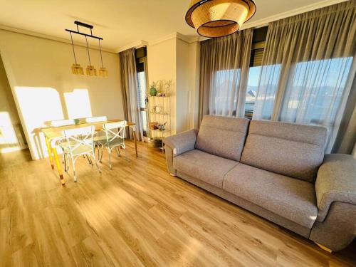 sala de estar con sofá y mesa en Luminoso ático con terraza en Santander