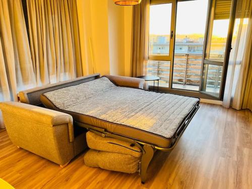 Bett in einem Zimmer mit einem großen Fenster in der Unterkunft Luminoso ático con terraza in Santander