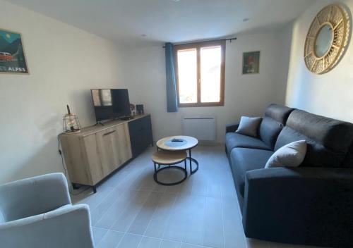 a living room with a couch and a table at T2 à 150m du village in Chateauroux-les-Alpes