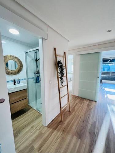 a bathroom with a glass shower and a ladder at Luminoso ático con terraza in Santander