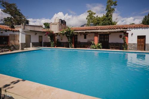 a swimming pool in front of a house at El Hospedaje in Cafayate