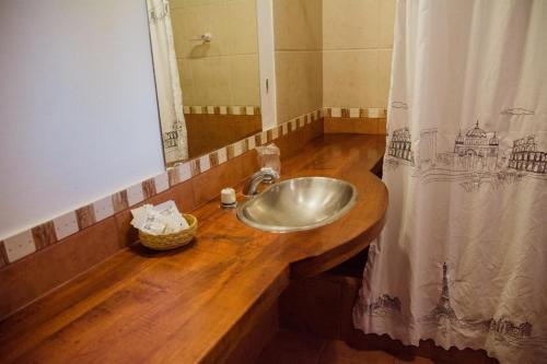 een badkamer met een wastafel en een douchegordijn bij El Hospedaje in Cafayate
