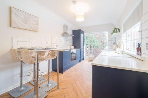 a kitchen with blue and white counters and a table at Hamlet's Nest in Stratford-upon-Avon