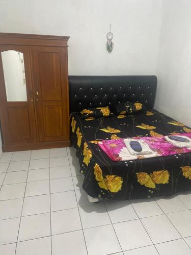 a bedroom with a bed with a black head board at Wijaya homestay in Subang