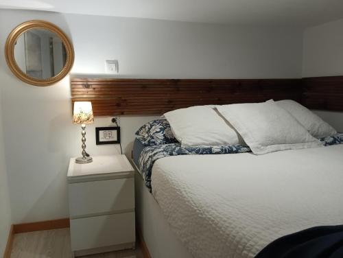 Schlafzimmer mit einem Bett und einem Spiegel an der Wand in der Unterkunft El Pozo-Villalobos Suite in Madrid