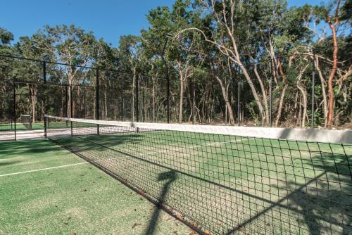 a tennis court with two tennis rackets on it at Lumina at LOSANTOS Tulum in Tulum