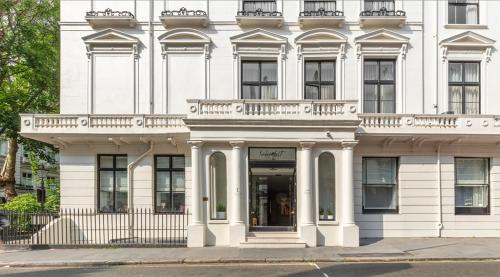 a white building with a balcony on a street at Inhabit Queen's Gardens, a Member of Design Hotels in London