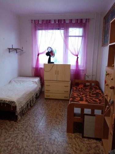 a bedroom with two beds and a dresser and a window at Pohodlná bytovka in Prešov