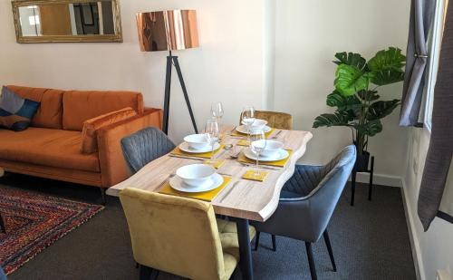 a dining room table with chairs and a couch at Beautiful Modern Coventry City Centre Apartment in Coventry