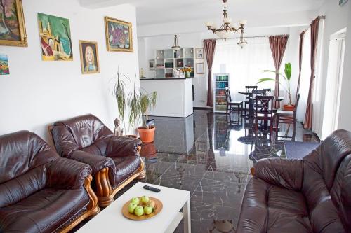 - un salon avec des canapés et une table avec un bol de fruits dans l'établissement Hotel Nova Bital, à Popeşti-Leordeni