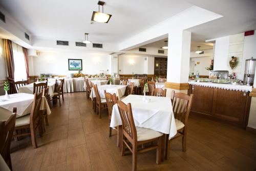 a dining room with white tables and chairs at Hotel Santa Mafalda in Fátima