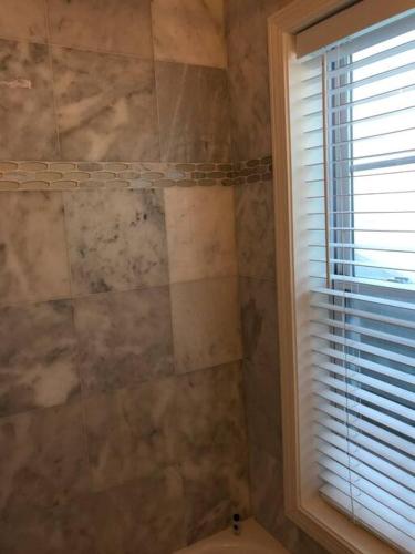 a bathroom with a shower with a toilet and a window at CLARENDON,SUPRLOCATION,8ppl,PRIVATE,METRO,PARK in Arlington