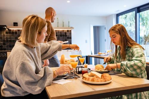 two girls sitting at a table eating food at B&B Ginnekenshoeve in Beerse