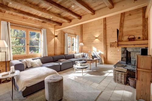 a living room with a couch and a fireplace at Chalet Hollygotty - OVO Network in La Clusaz